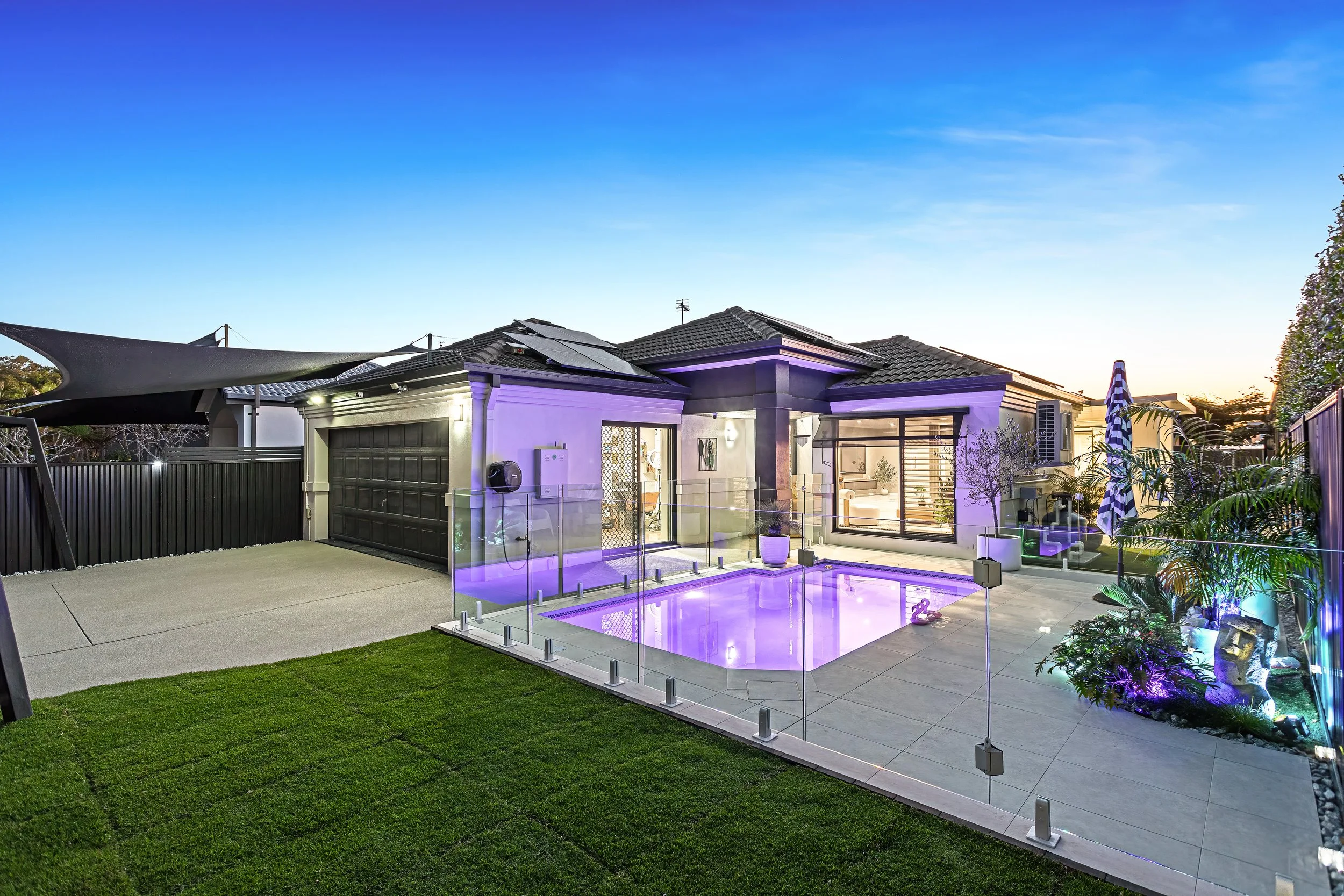  Twilight exterior of 13 Zac Avenue, Coombabah showing the pool, garage and landscaped side yard 