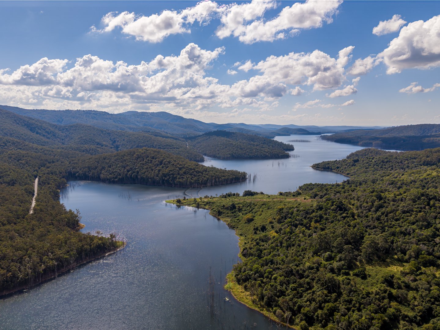 Drone aerial photograph of Advancetown reservoir surrounded by green mountain ranges