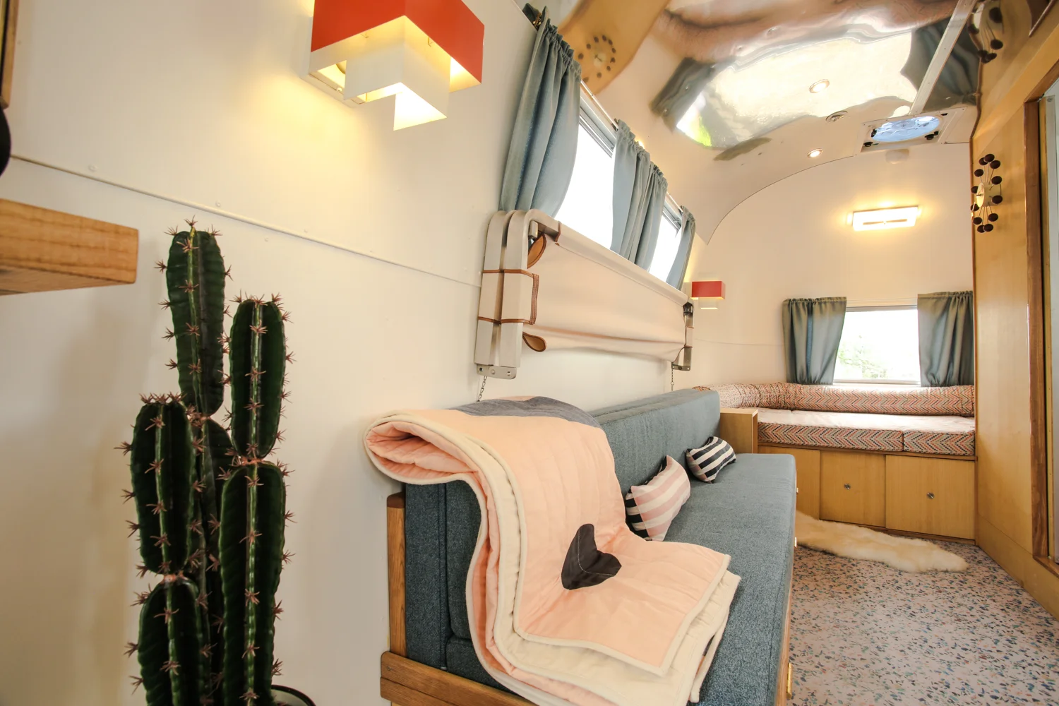 Interior-view from the door looking down the bus. Fold out Ash custom made double bed and canvas bunk attachment.