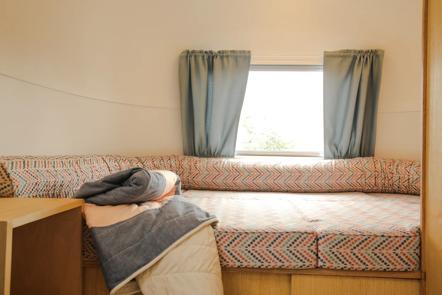 Interior-Back of the bus. Day bed with bolster and custom made quilt.