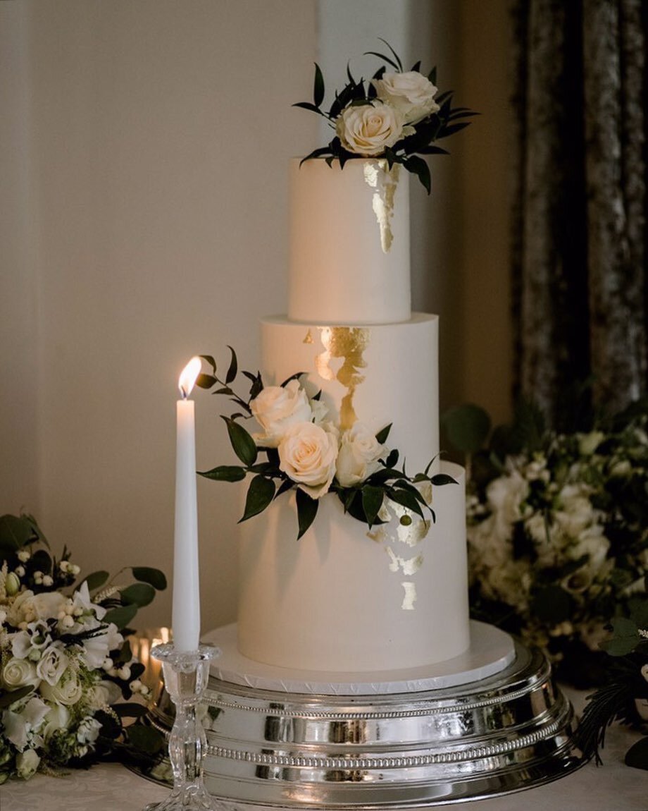 Sharp, simple, classic white silky Swiss meringue buttercream with a touch of gold leaf finished with fresh flowers 🤍✨ captured beautifully by @emmyshoots at @merrydalemanor 
.
.
.
.
#simpleweddingcake #goldleaf #cakepic #cheshirecakes #merrydaleman