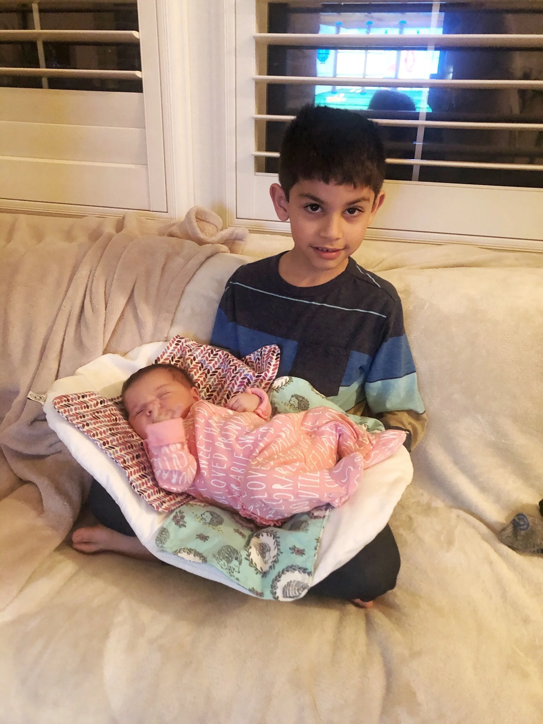 One of the many uses of the Topponcino, helps older children hold the newborn with ease and security.