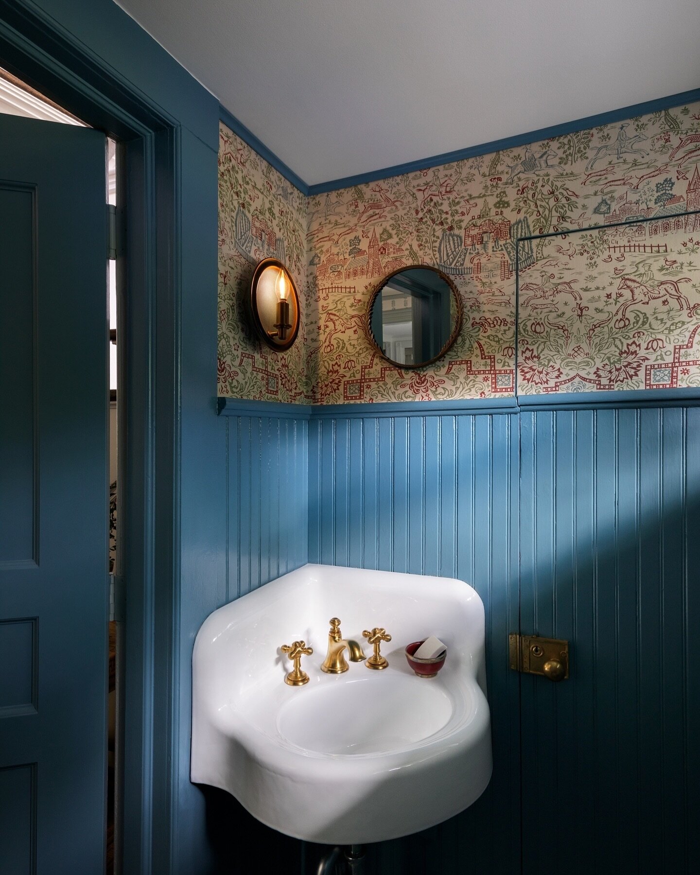 Check out the charming powder room in our boutique hotel project at @StonoverFarm in the Berkshires. It showcases the moody color Blue Dusk by @BenjaminMoore and @ClaremontFurnishing Rosa Bernal Country Life walls. The color scheme is filled with sha