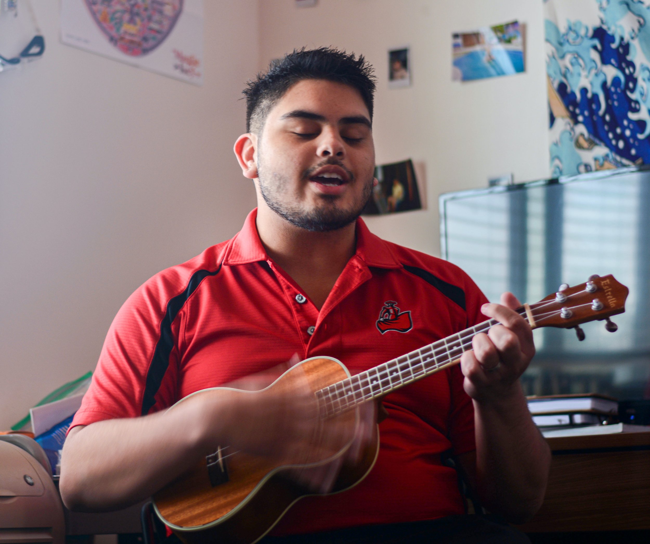   CSUN Sophomore and Resident Advisor Michael Gonzalez playing ukulele in his dorm (Sam Landau | Scene Magazine)  
