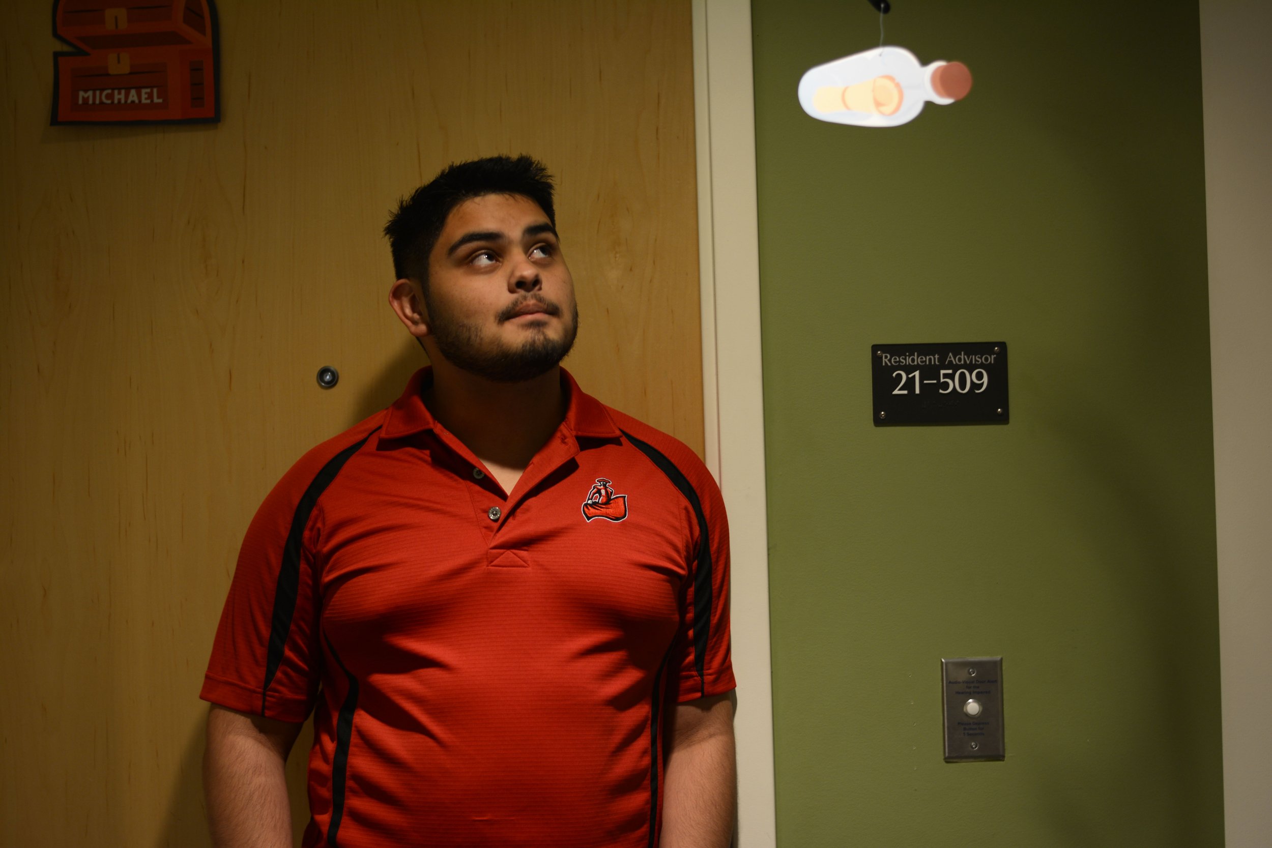  CSUN Sophomore and Resident Advisor Michael Gonzalez outside his dorm room in Shore Pine Hall. (Sam Landau | Scene Magazine)  