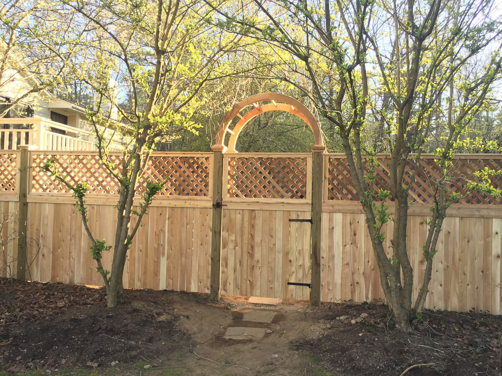 cedar arbor with board and lattice fence