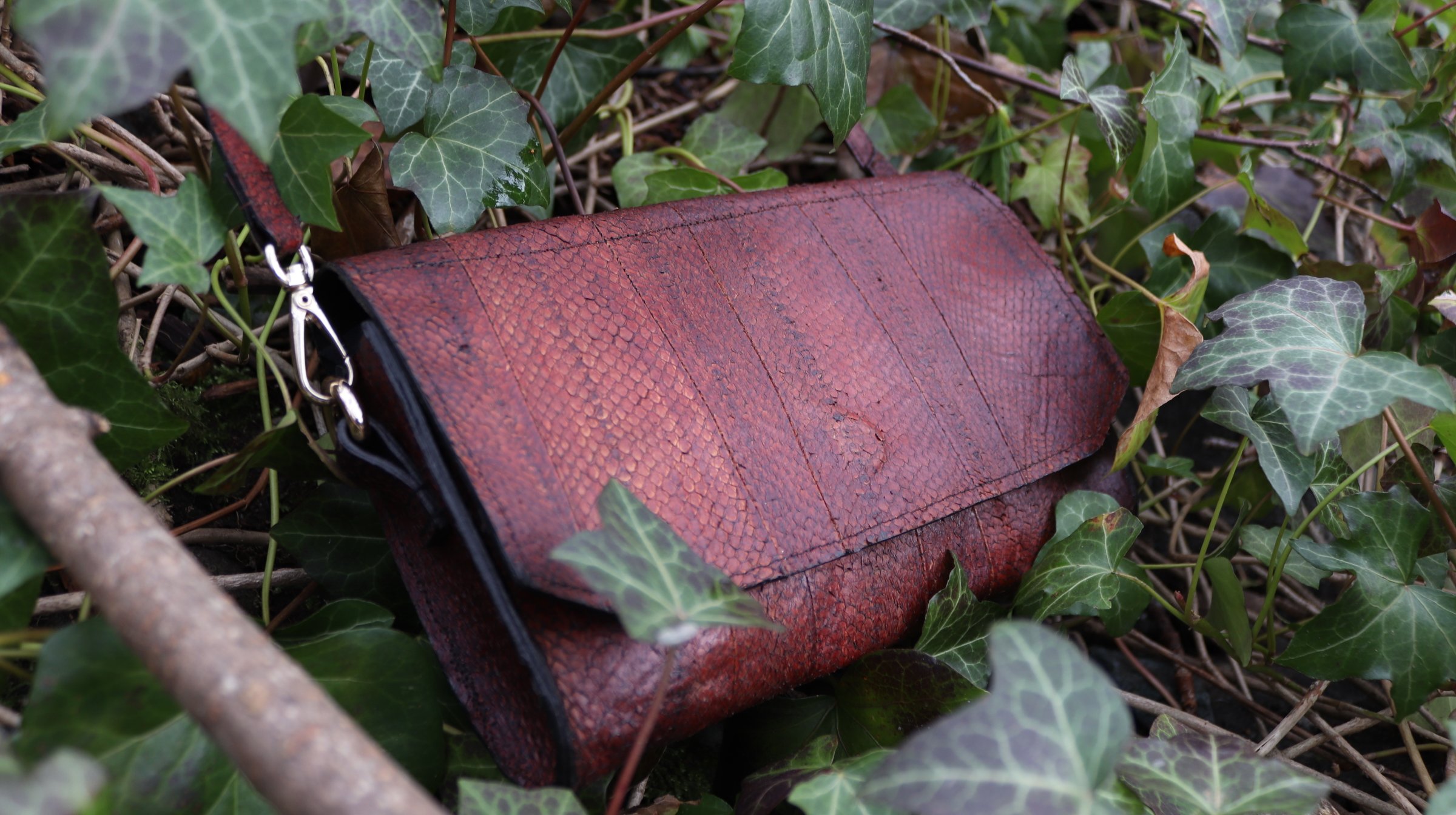 A bourbon brown fish leather clutch purse with metal hardware 