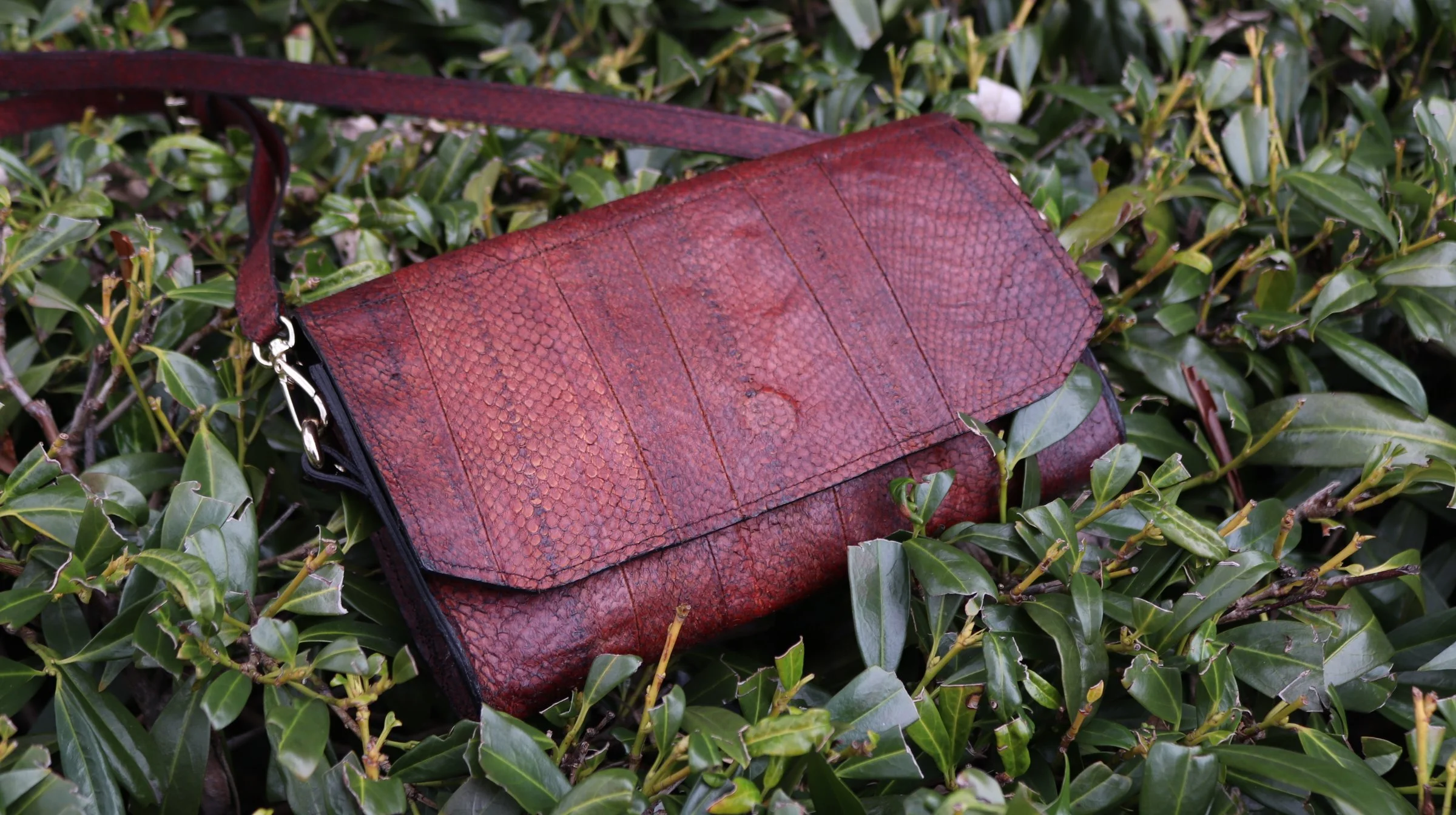 A bourbon brown fish leather clutch purse with metal hardware 