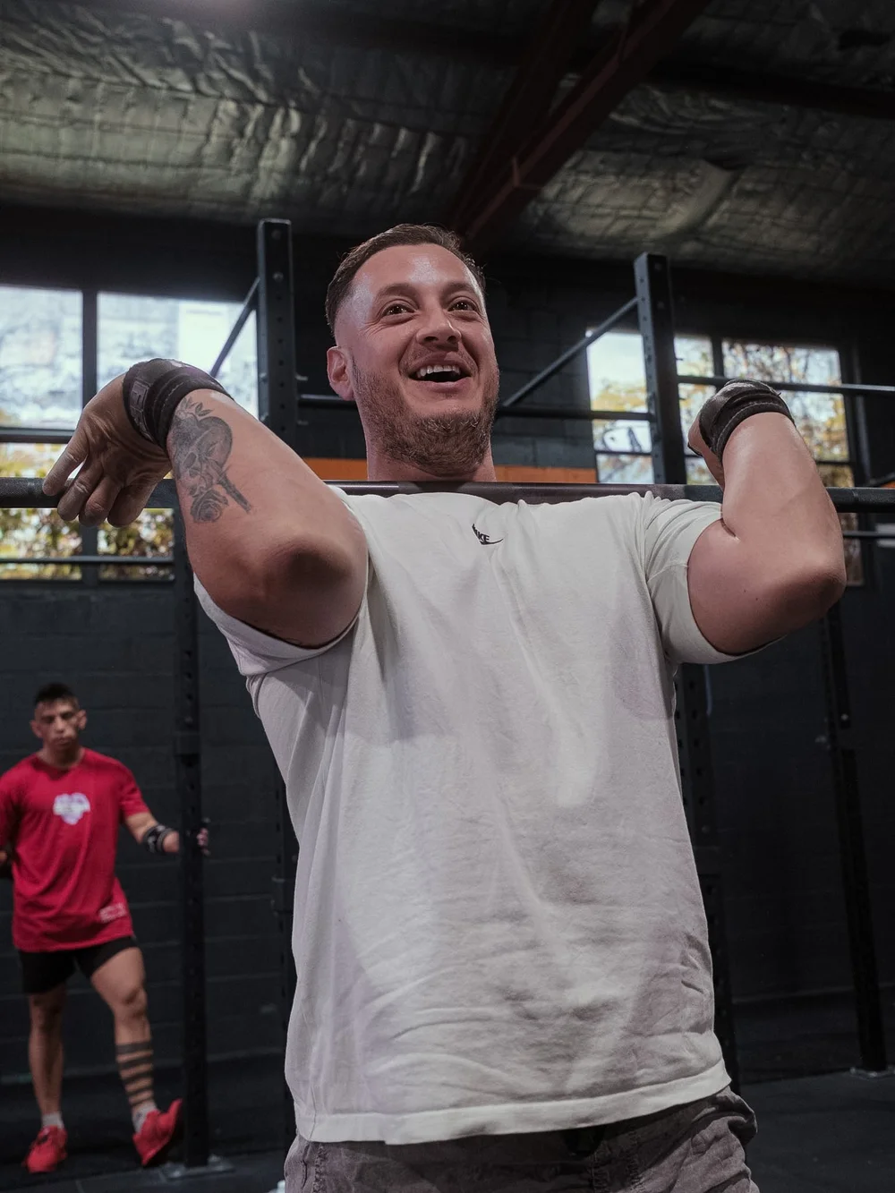 Member smiling with a barbell in the front rack