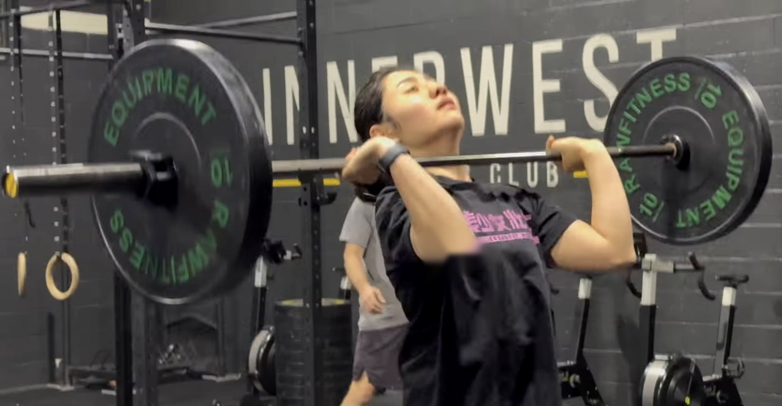 Member doing a barbell push press in a CrossFit class
