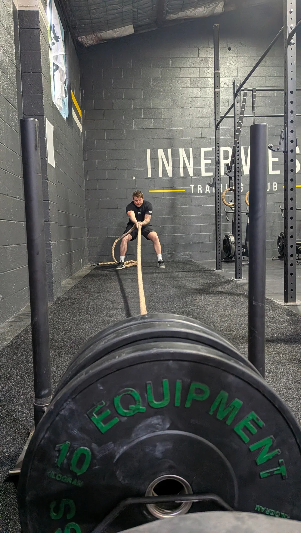 Member pulling a loaded sled with a rope in a HYROX / Engine session