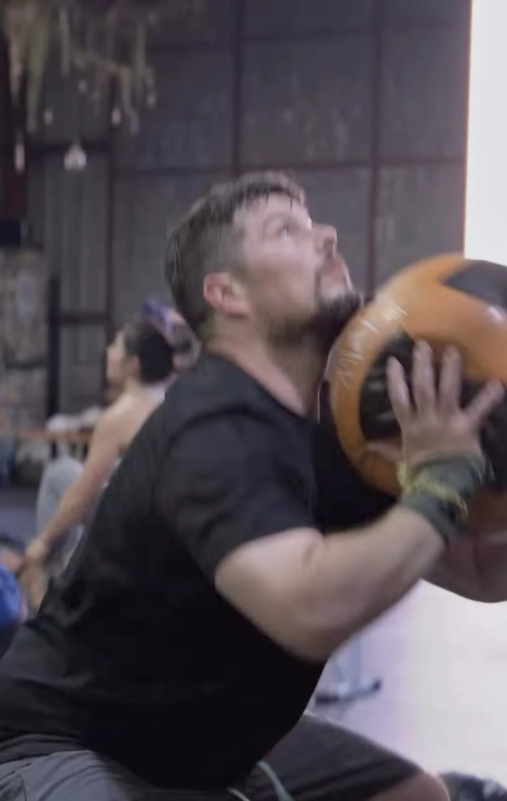 Member training with a medicine ball in a HYROX session