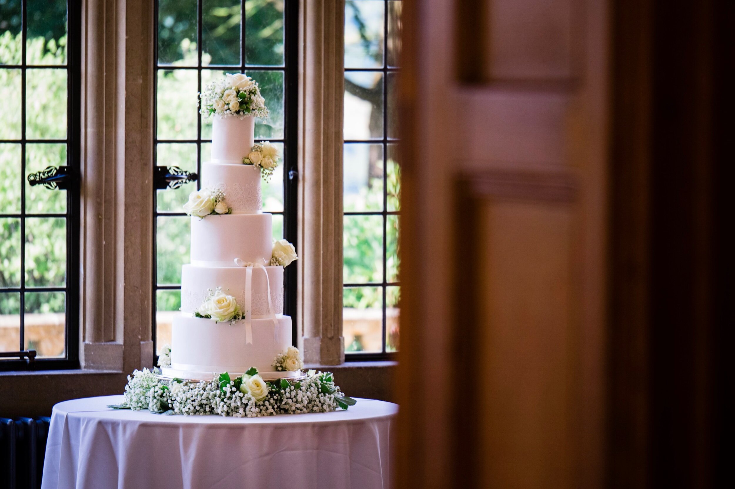 Gorgeous wedding cake next to a big window at a lovely wedding venue in Bristol