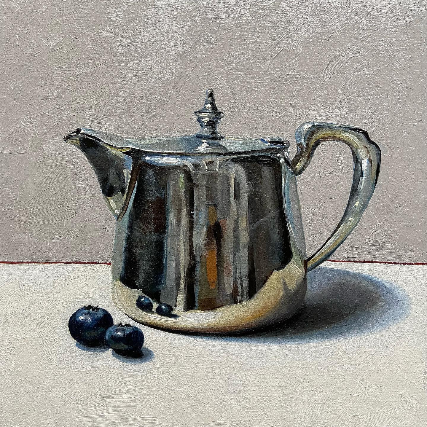 Silver teapot with blueberries