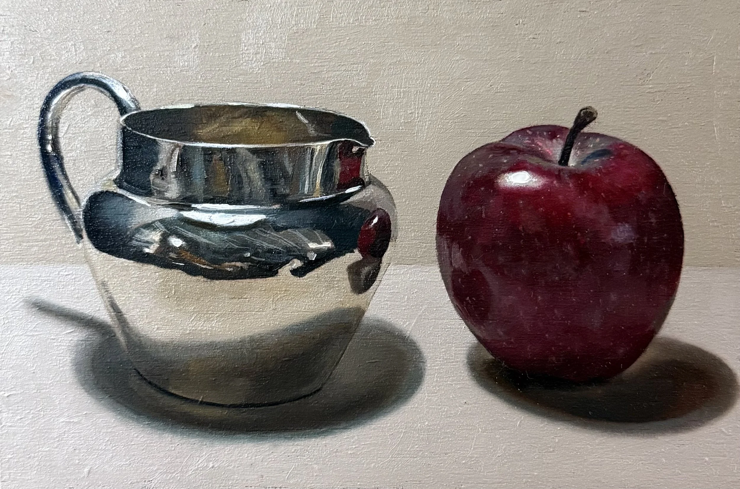 Dark red apple with silver jug