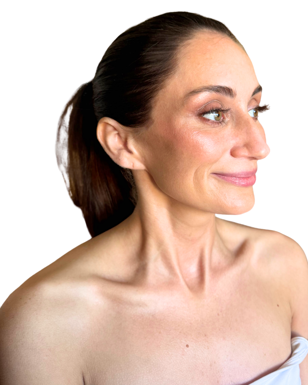 A close-up profile of a smiling woman with brown hair tied back, showing her bare shoulders and neck against a black background.