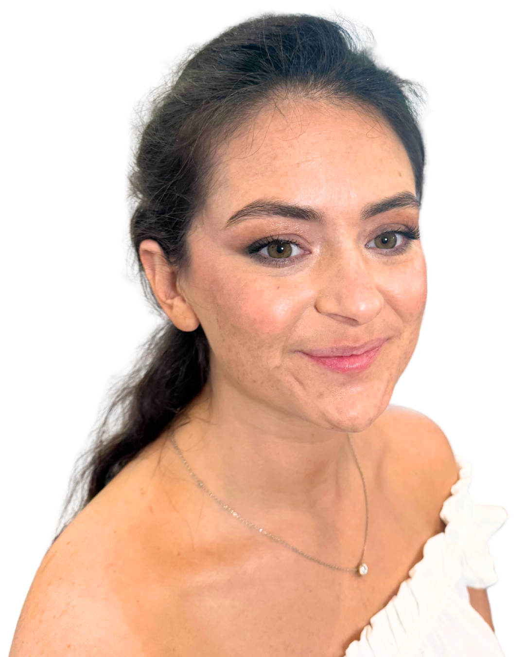 A smiling woman with makeup and shoulder-length dark hair, wearing a white off-shoulder top and a silver necklace.
