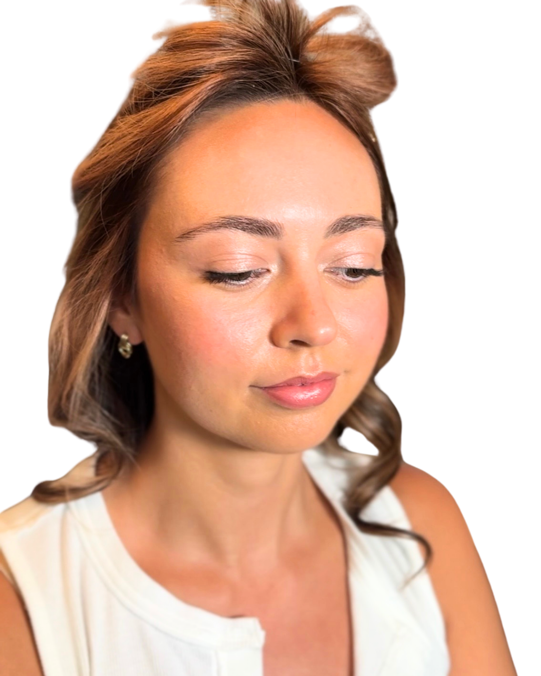 Close-up of a woman with light brown, shoulder-length hair, wearing earrings and a white top, looking downward with a peaceful expression.