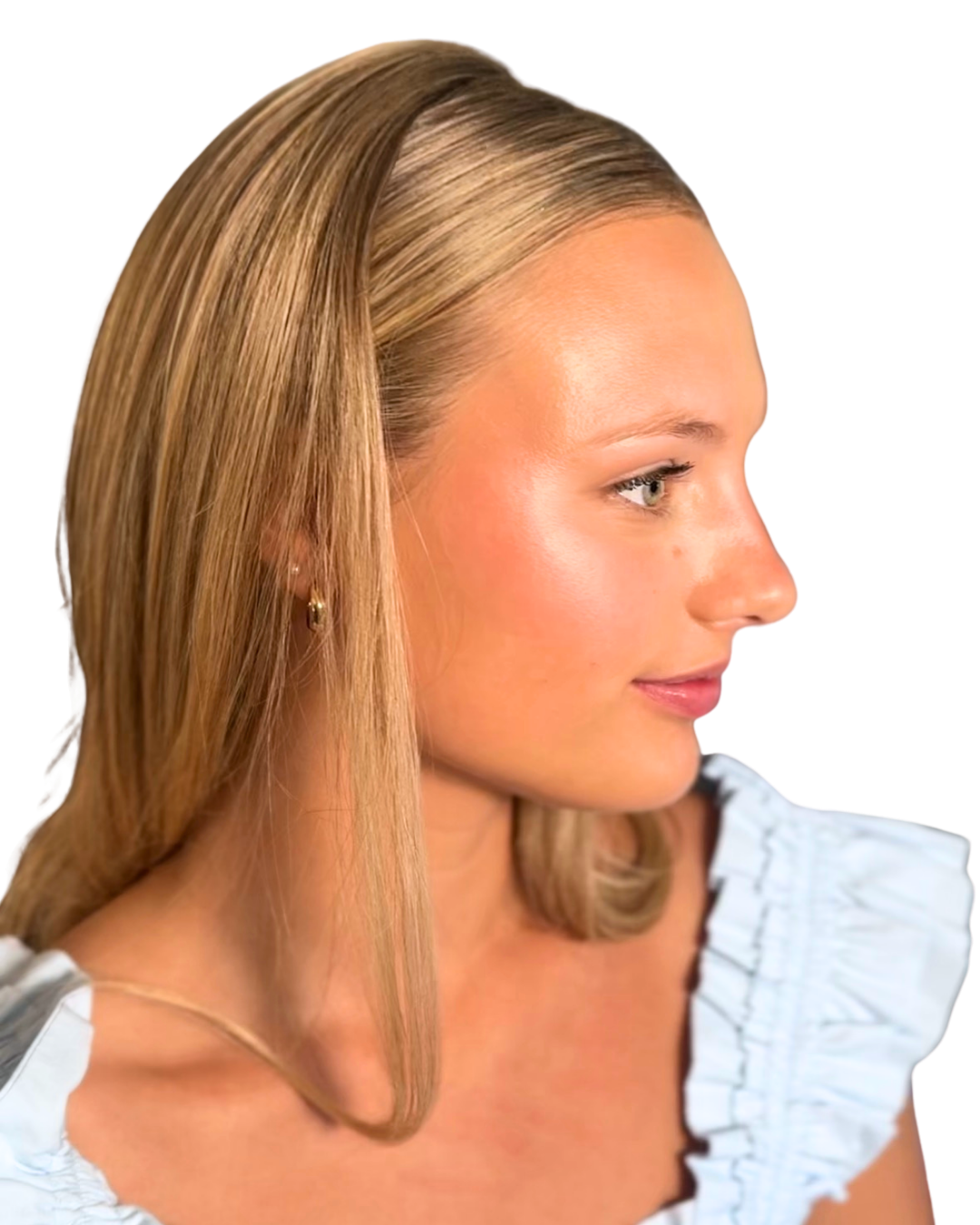 Side profile of a woman with blonde hair, wearing small hoop earrings, and a light blue ruffled top.