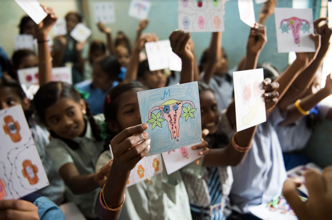 Workshop participants hold up their finished coloring cards designed to destigmatize the menstrual cycle.