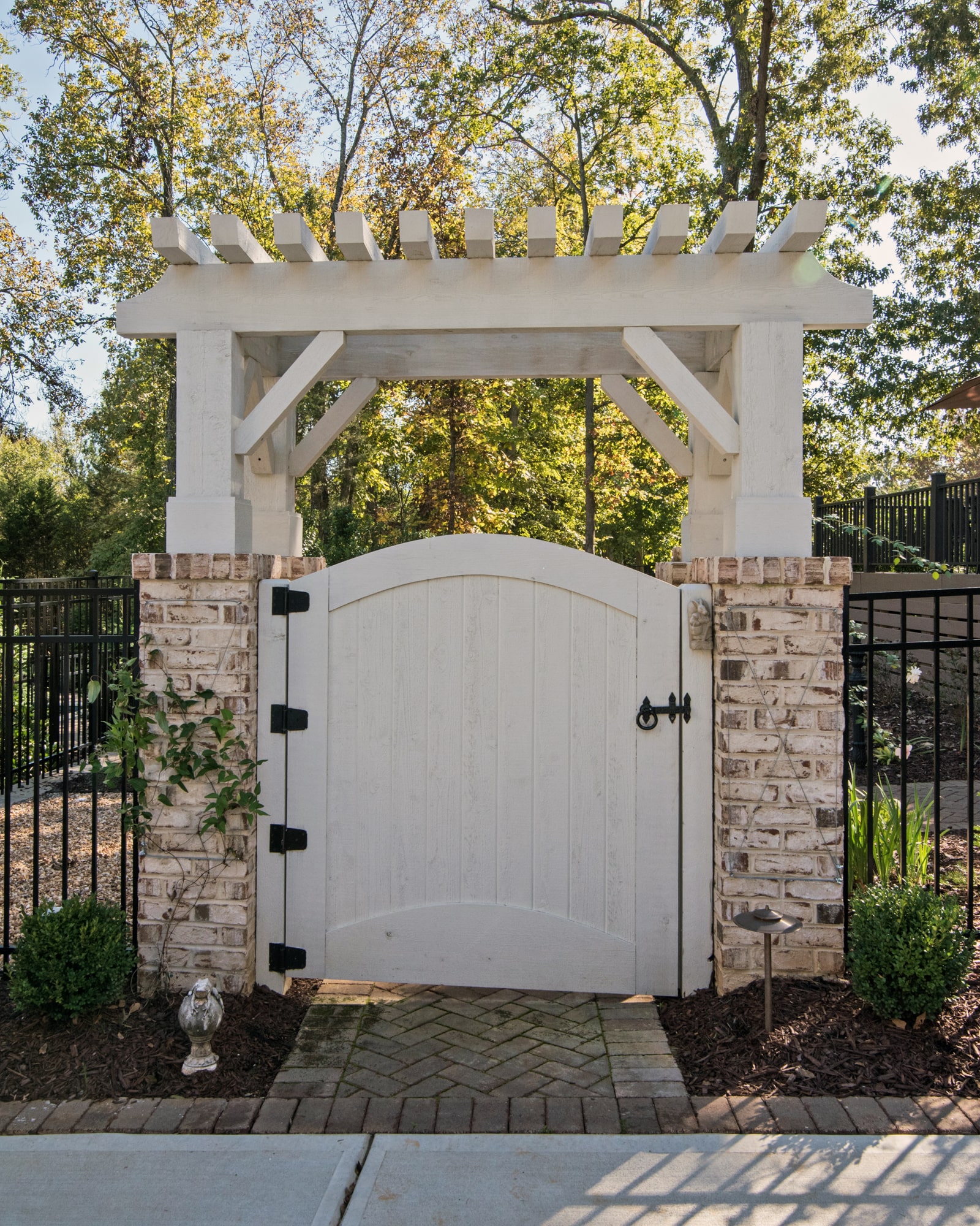 Beautiful pergola at the gate into the back hard ties in to the home and the landscaping perfectly.