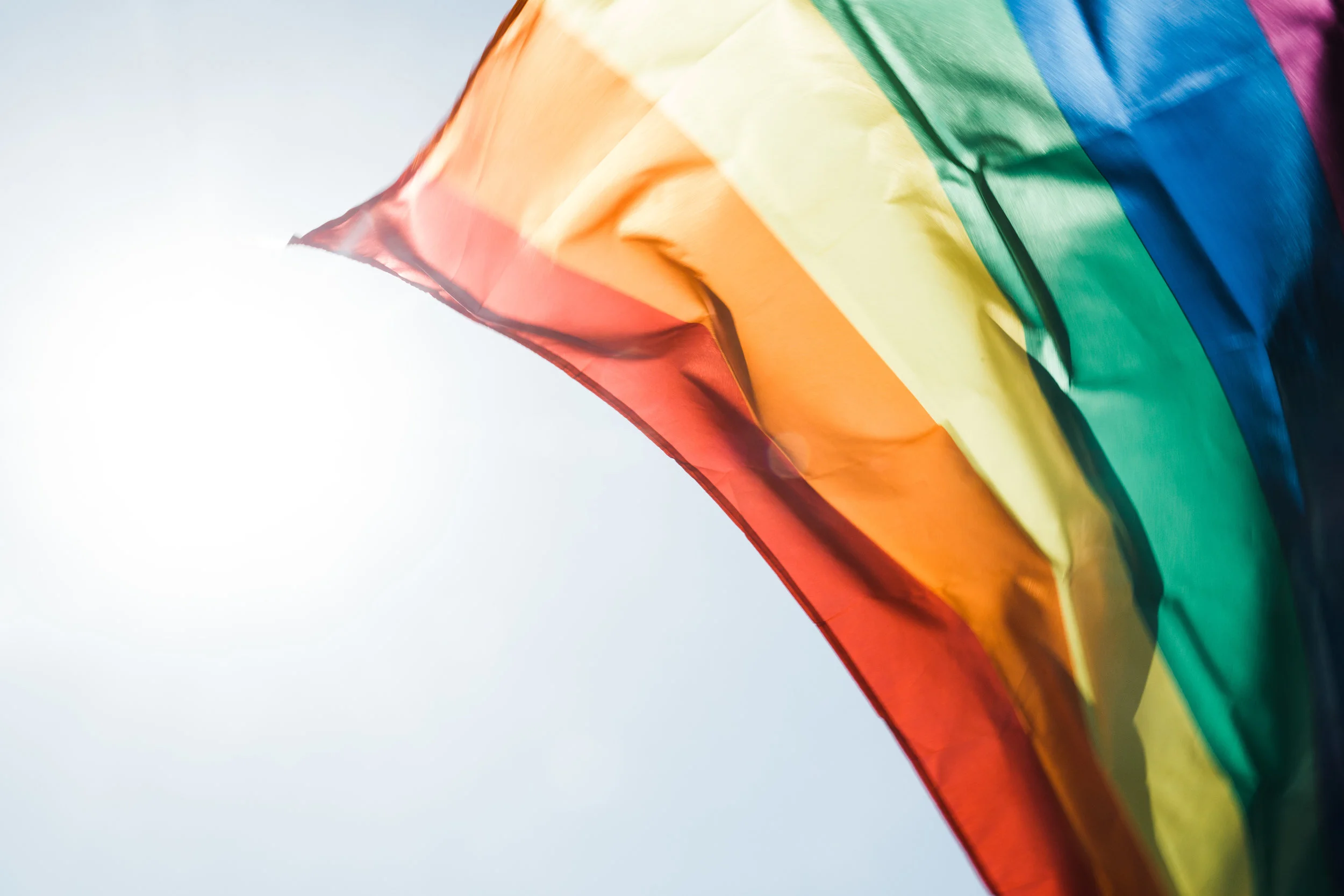 Rainbow flag flying in the wind.