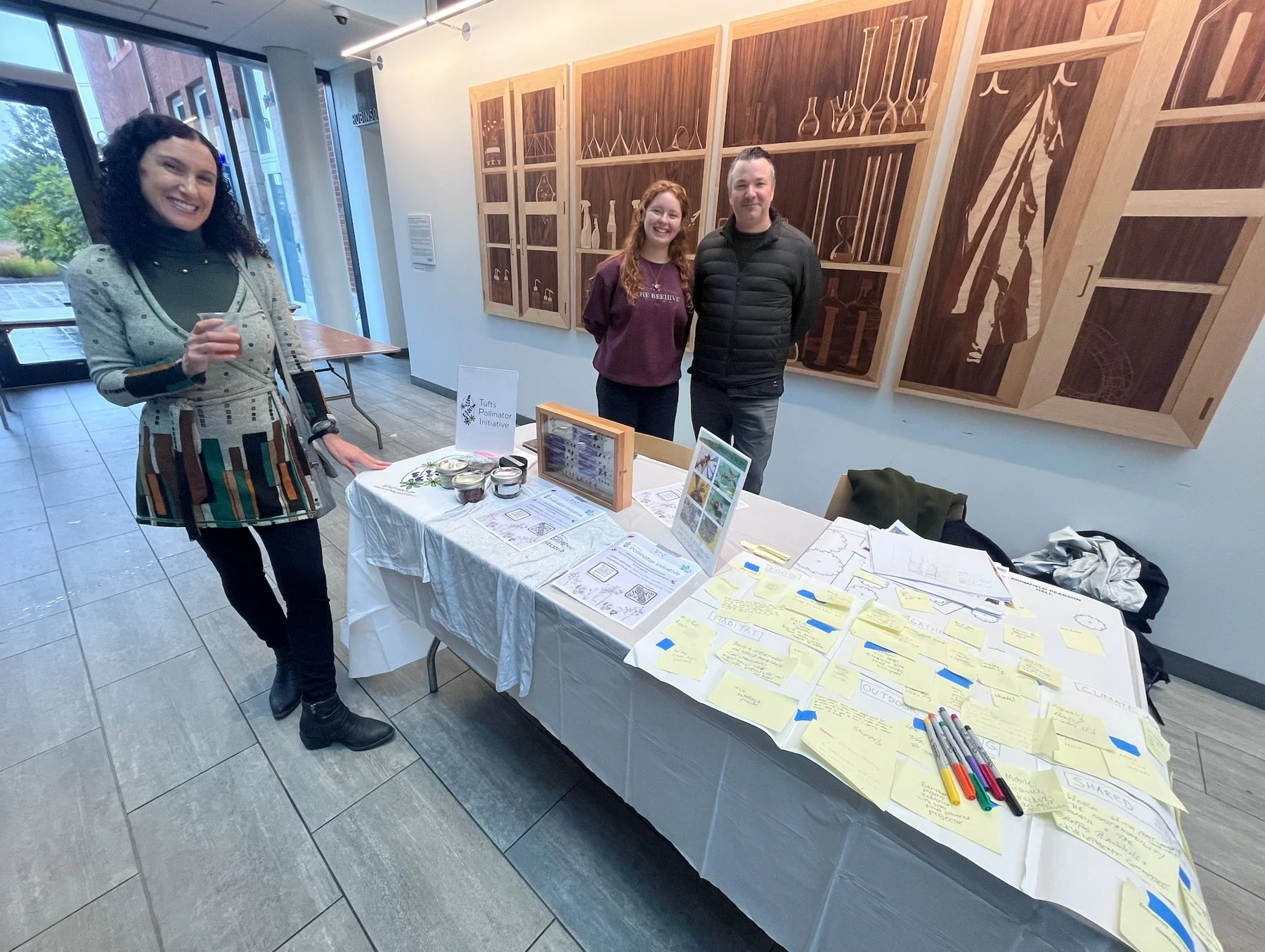 Three participants review drawings and notes at a Tufts Pollinator Initiative design session