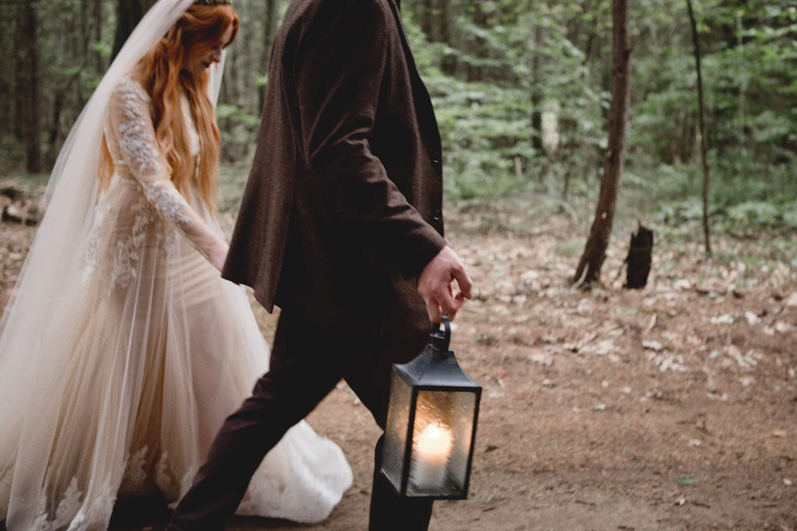 Bride + Groom walking through whispering springs forest with lantern