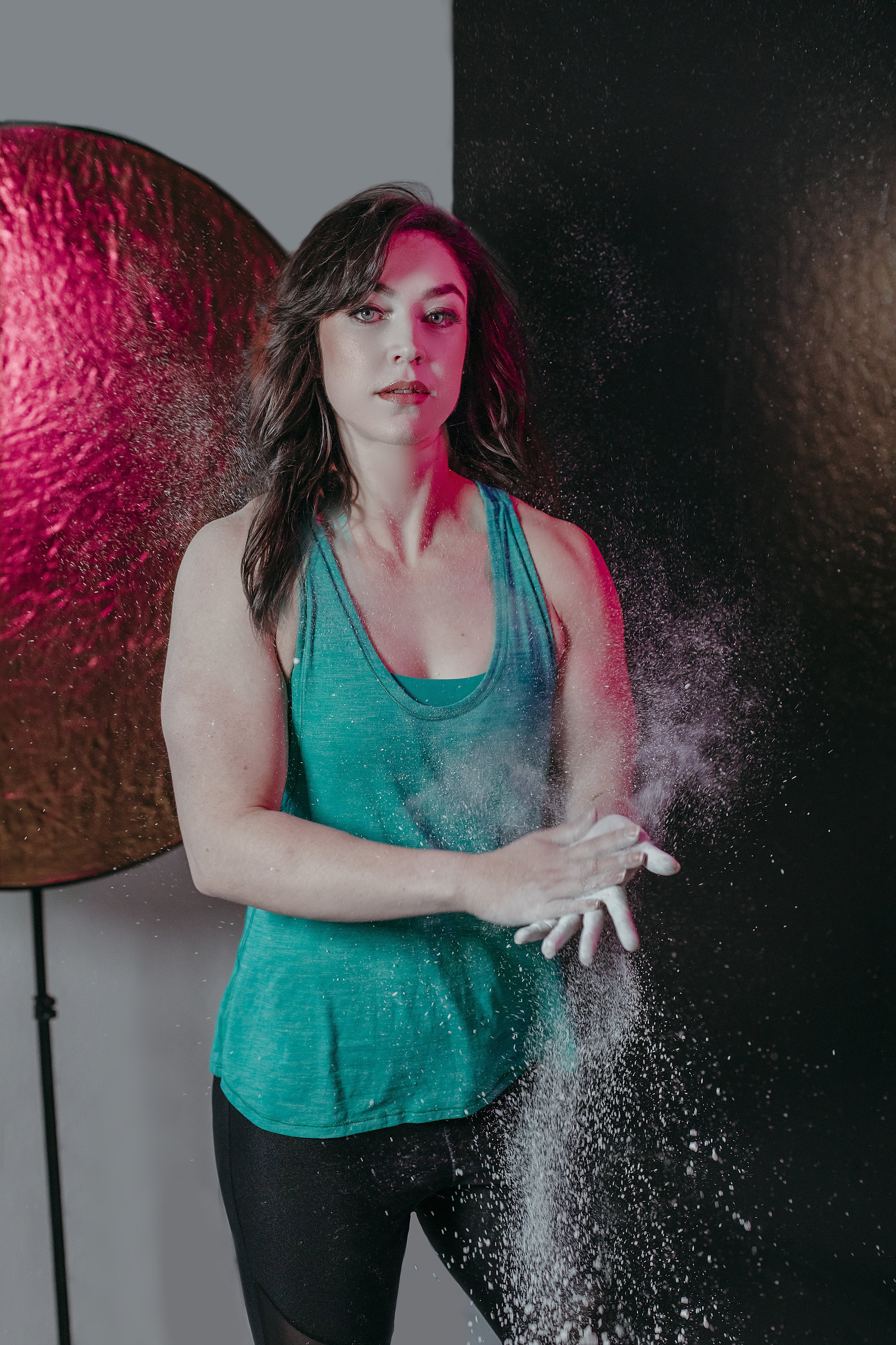 Portrait of Bailey looking into camera while clapping chalk dust between her hands