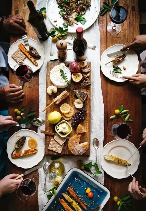 wine and cheese-fruit-crackers on board with people's hands.jpeg