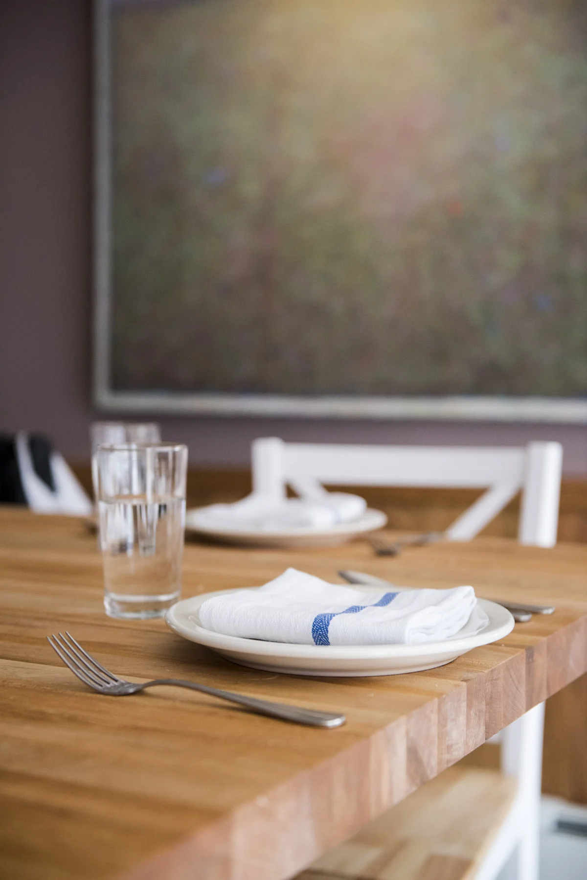 lightwoodendiningtable-with-silverware-table-settings-and-glass-cup.jpg