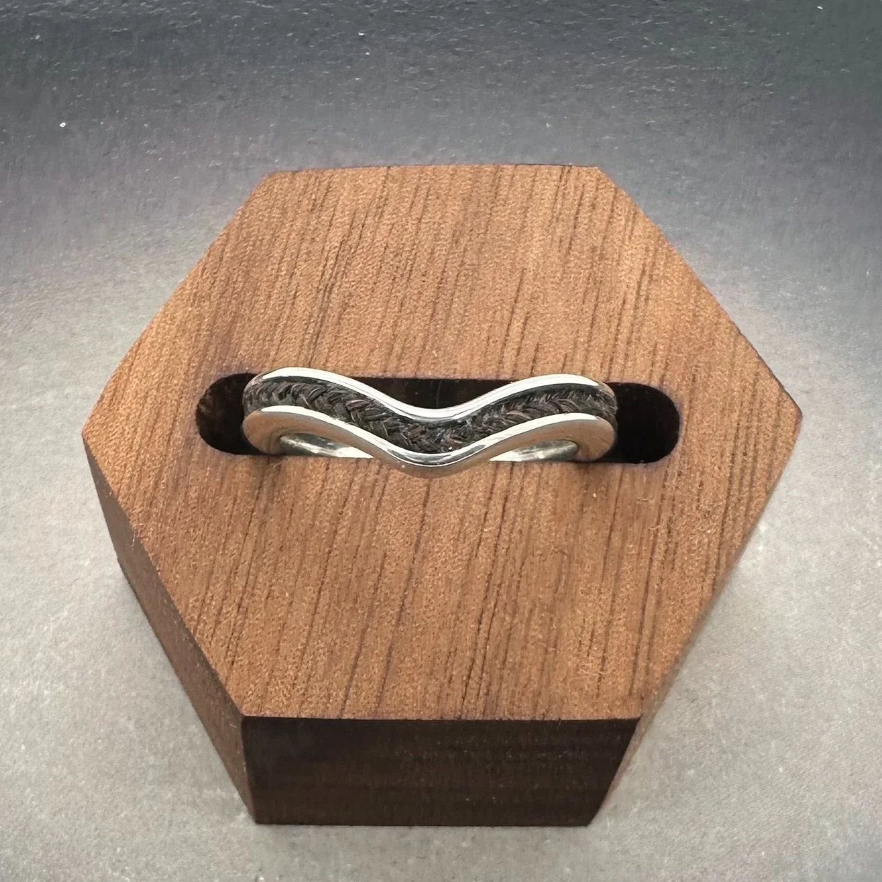 Chevron-shaped sterling silver ring with horsehair inlay, photographed from above.