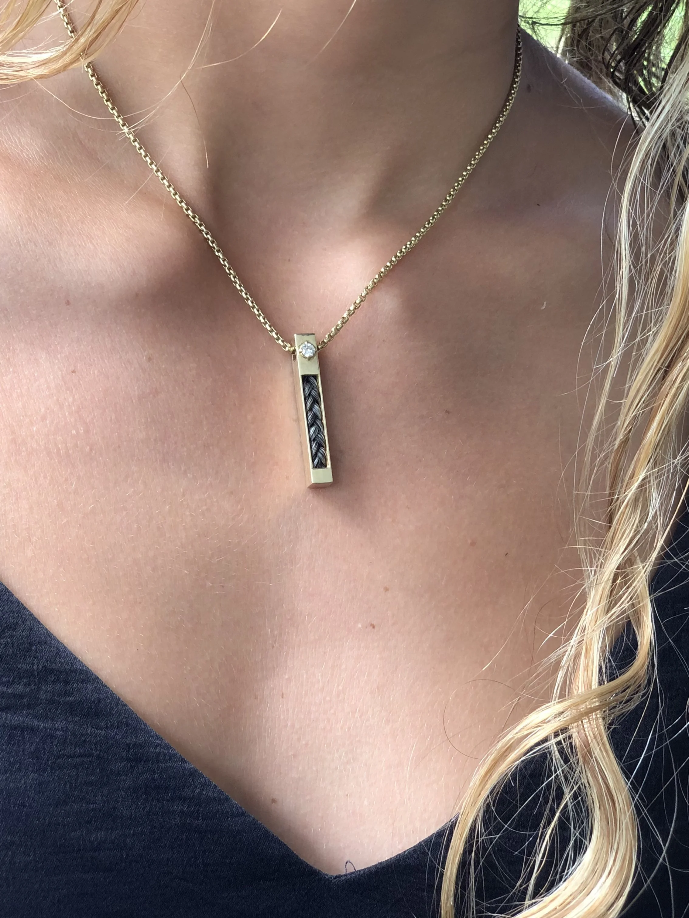 14Kt Gold Vertical Horse Hair Pendant with 3mm VS Diamond worn on person's neck