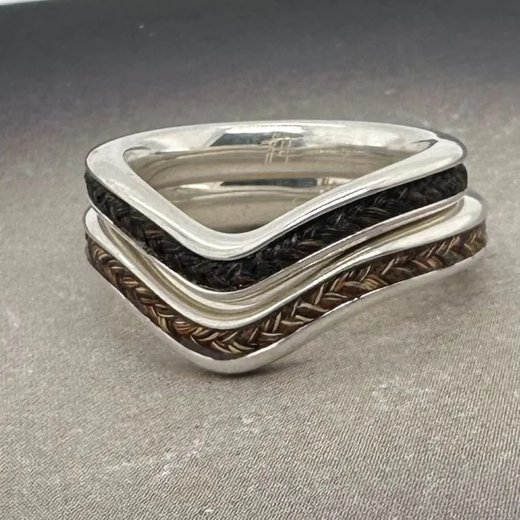 Stacked chevron and barefoot hoofprint horsehair rings in sterling silver, showing matching braided inlays.