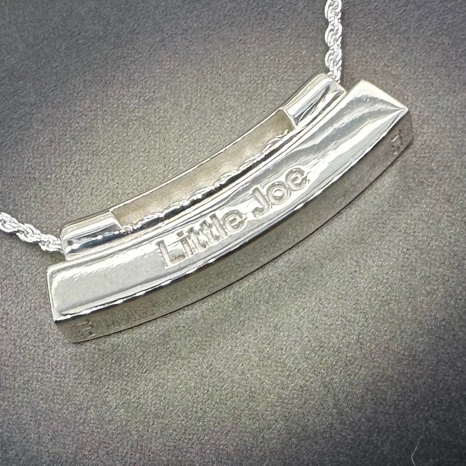 Reverse side of pendant showing engraving in bold, clean lettering.