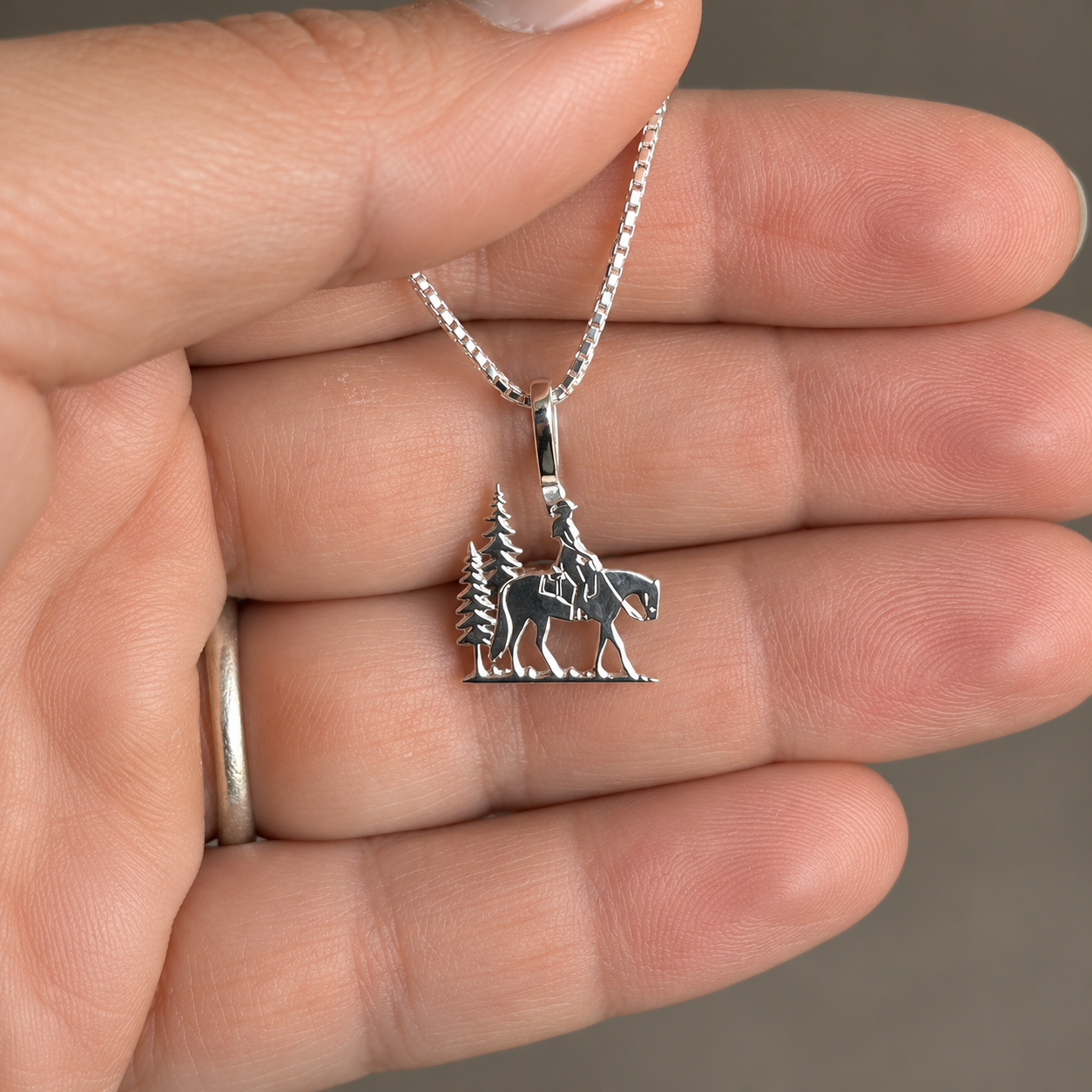 Silver Simple Bail Trail Rider Pendant in Hand.png