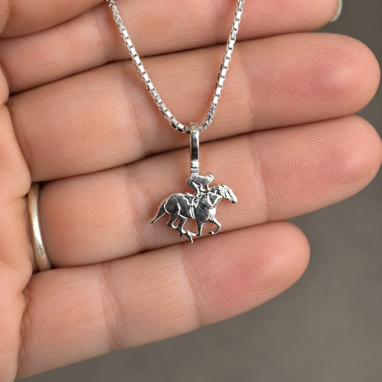 Silver Simple Bail Race Horse Pendant in hand.png