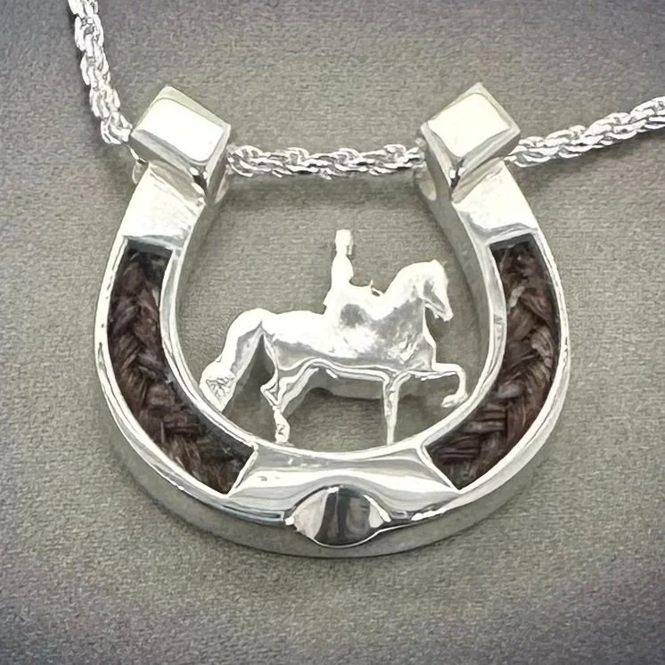 Sterling silver horseshoe pendant with horsehair inlay and a sidesaddle rider silhouette, displayed on rope chain.