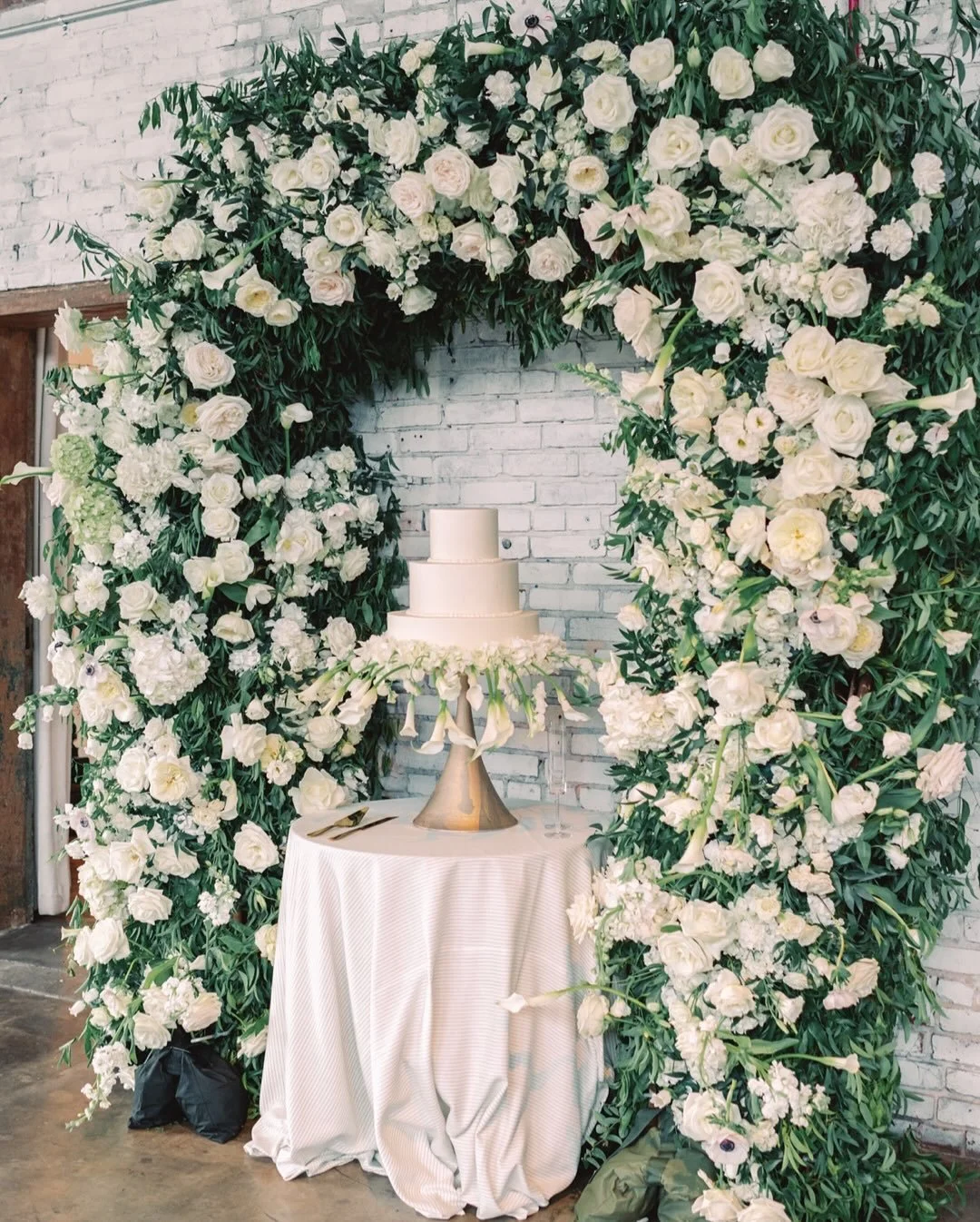 A sweet beginning to Anna &amp; Graham&rsquo;s forever 💍✨
Surrounded by soft petals, joyful hearts, and the scent of summer blooms, this cake stood beneath a flower arch as the first symbol of their new chapter. On a golden June day in Birmingham, A