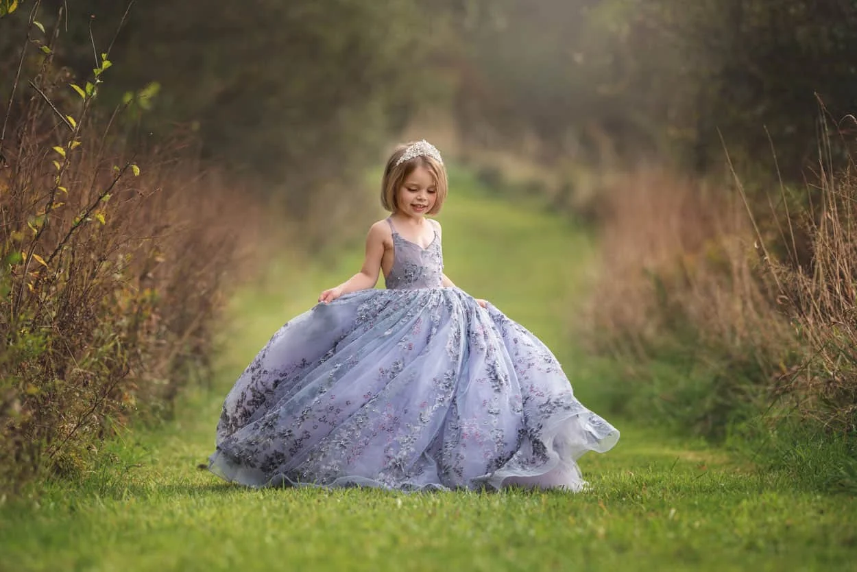 a little girl spinning in a beautiful purple dress 