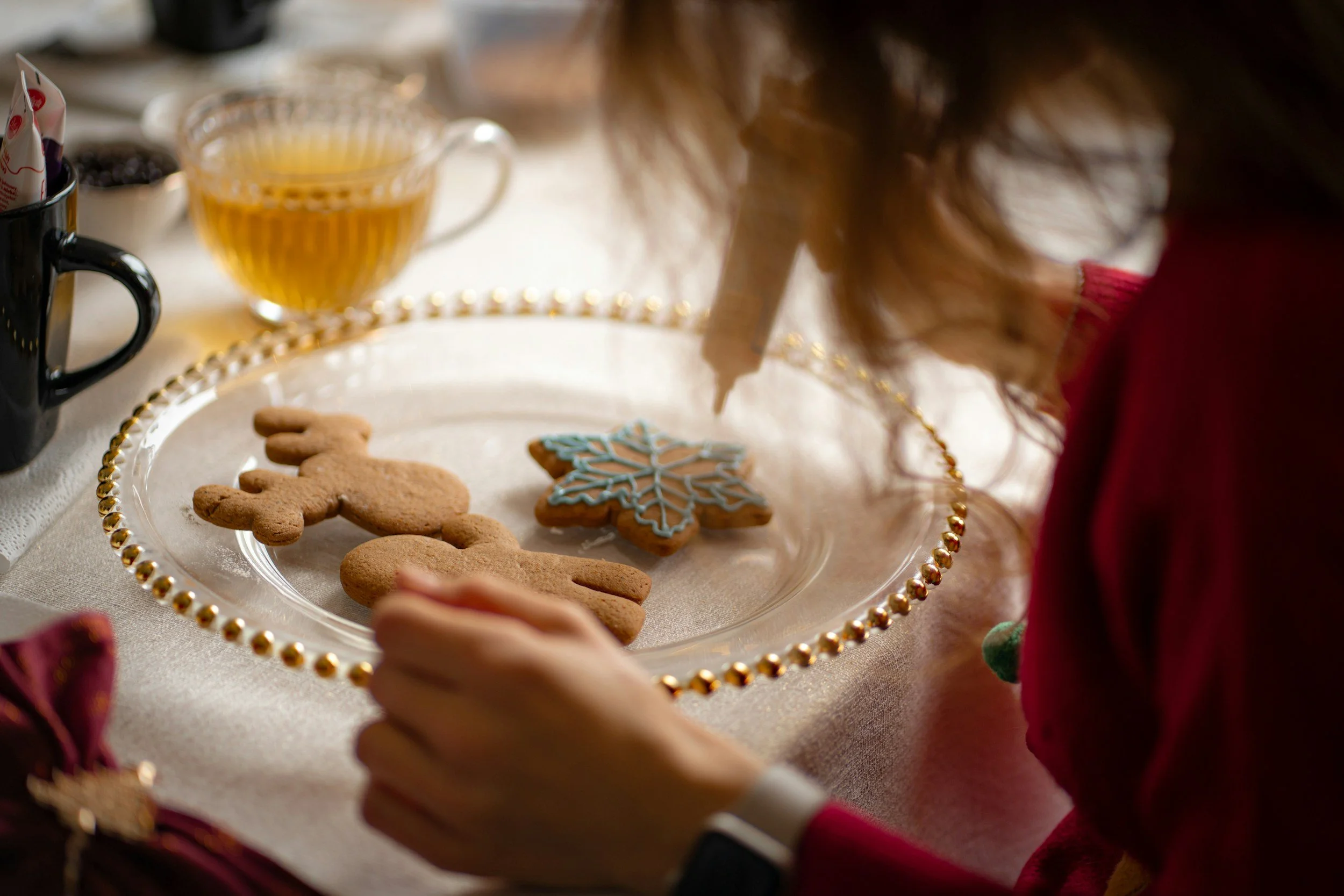 A child decorating a Christmas cookie