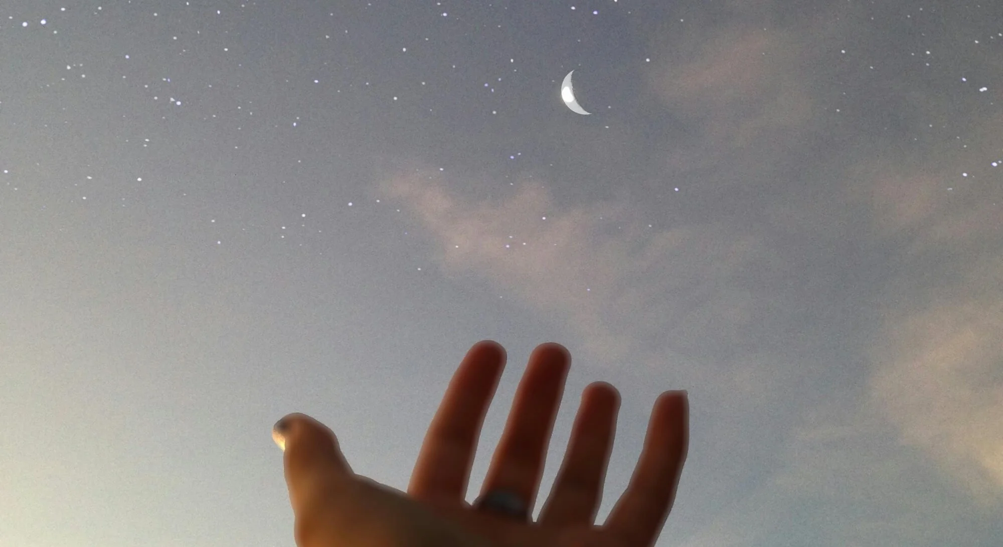 Hand reaching towards the night sky to symbolise the shoot for the moon approach in marketing
