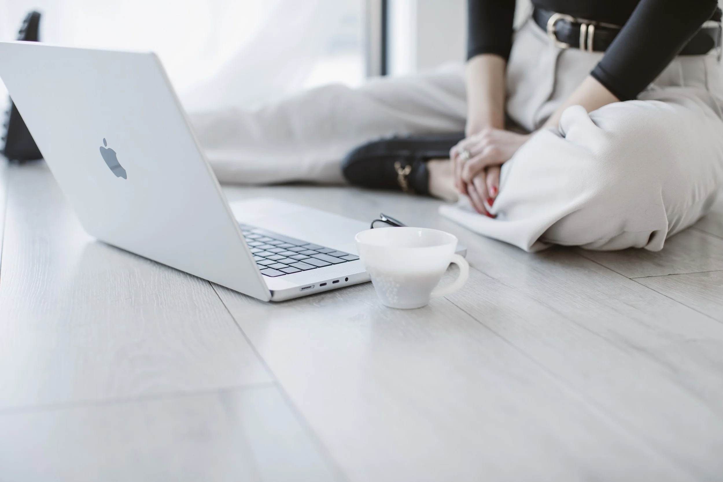 A laptop, a mug of coffee, and a woman.