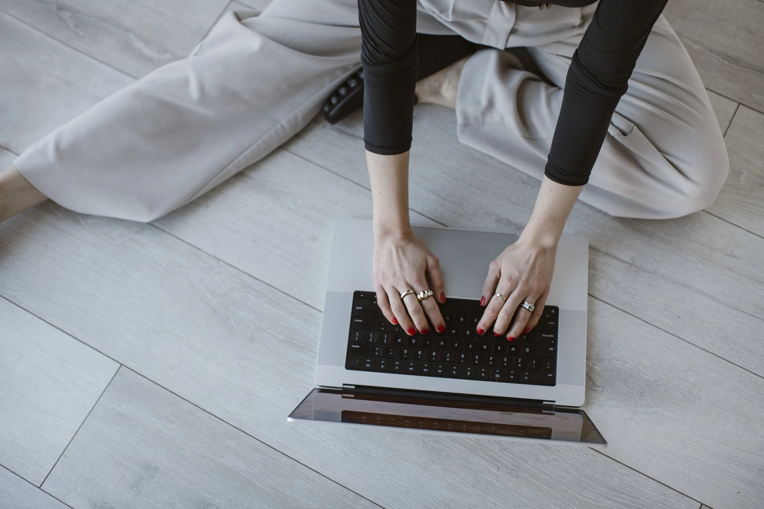 Shyanne Reynolds sitting on the floor typing on a laptop.