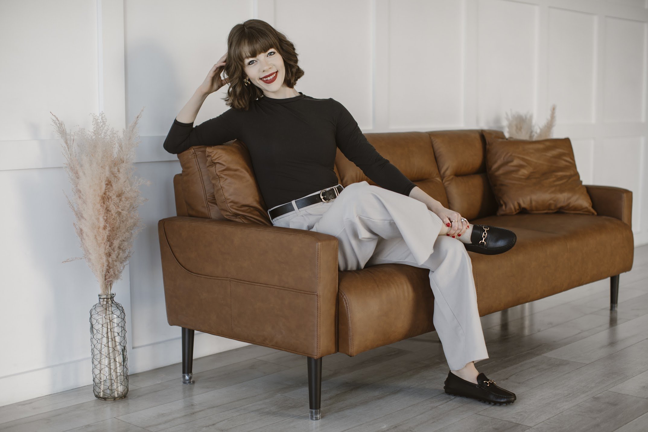 Shyanne Reynolds sitting on a leather couch smiling.