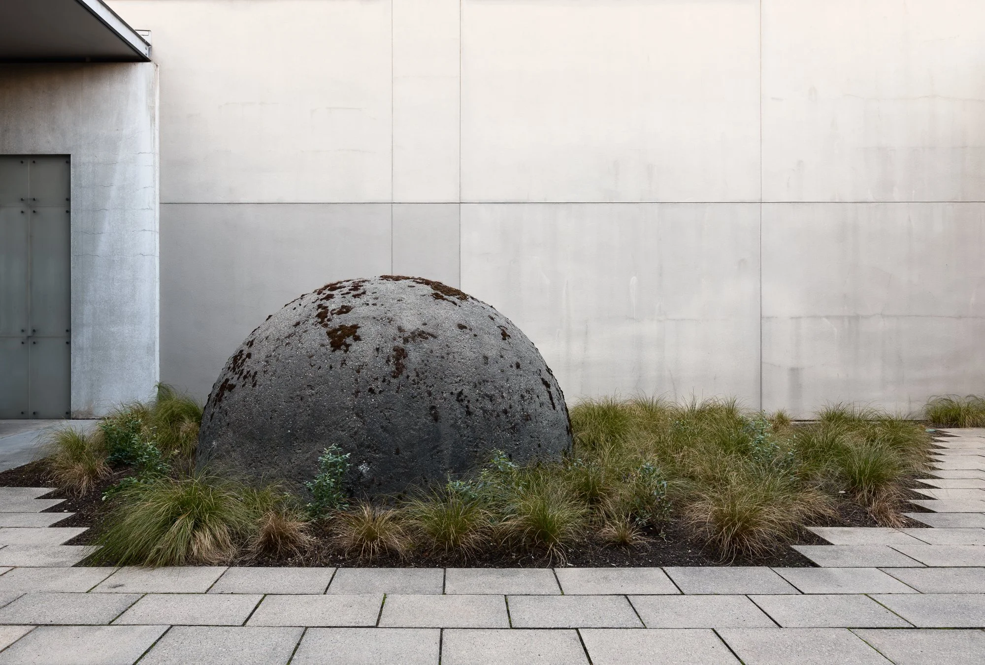 a large stone dome with plants around it
