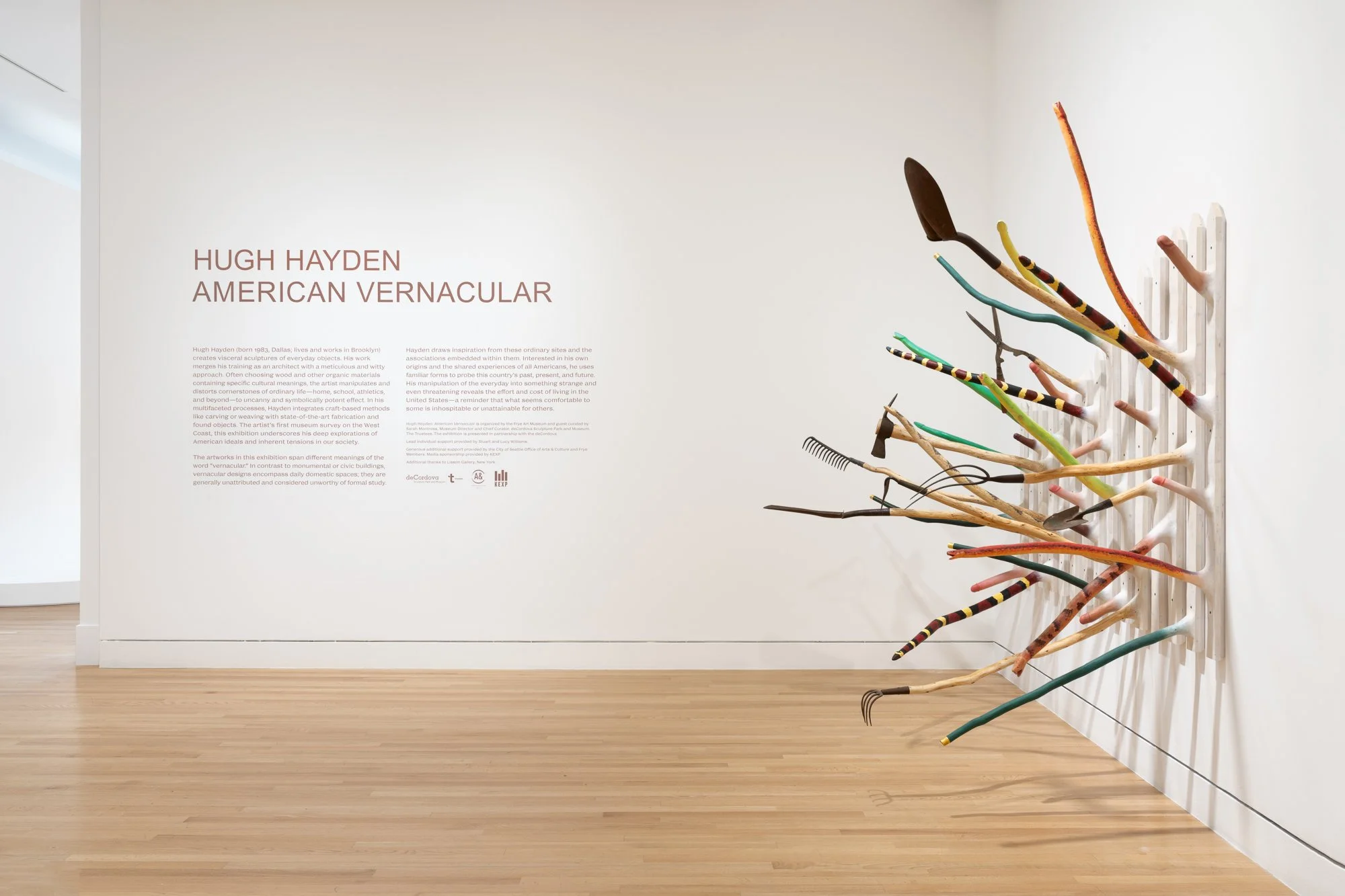 a large wood sculpture on one wall, and vinyl text on another