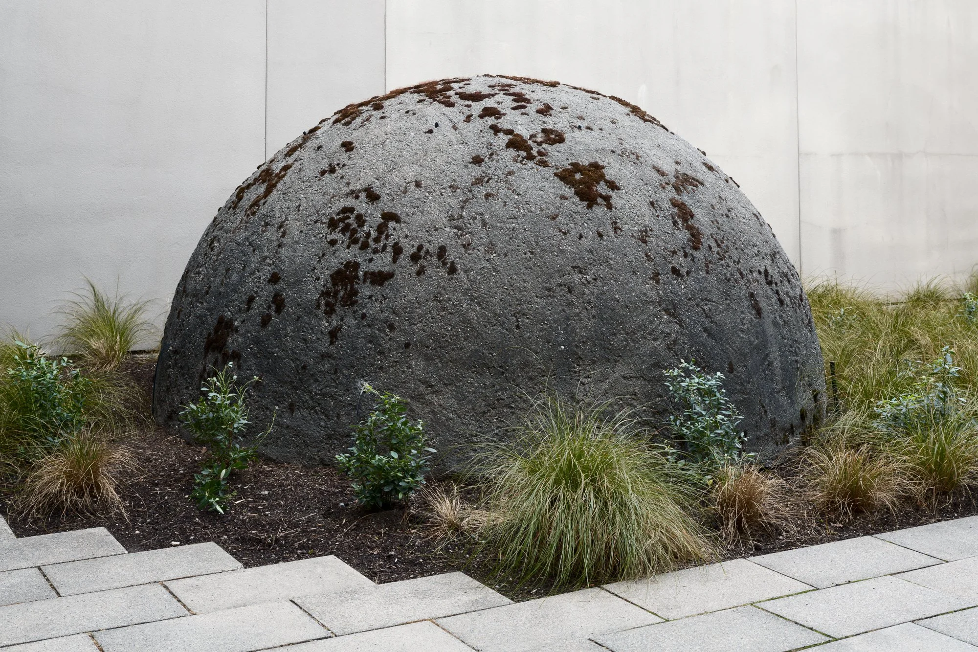 a large stone dome with plants around it