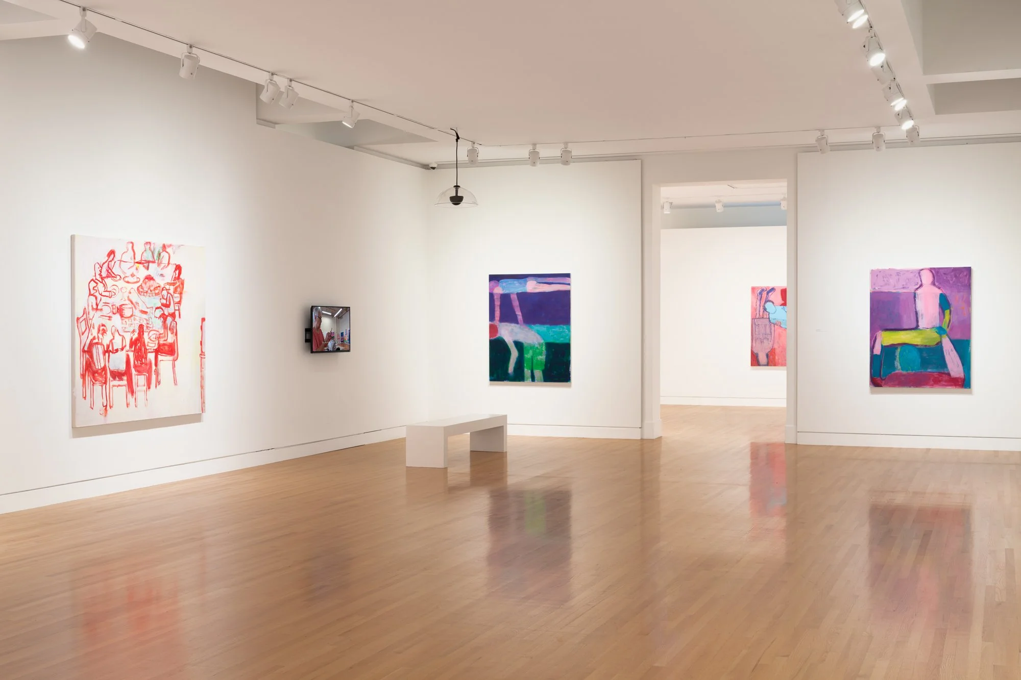 colorful paintings and a tv in a gallery