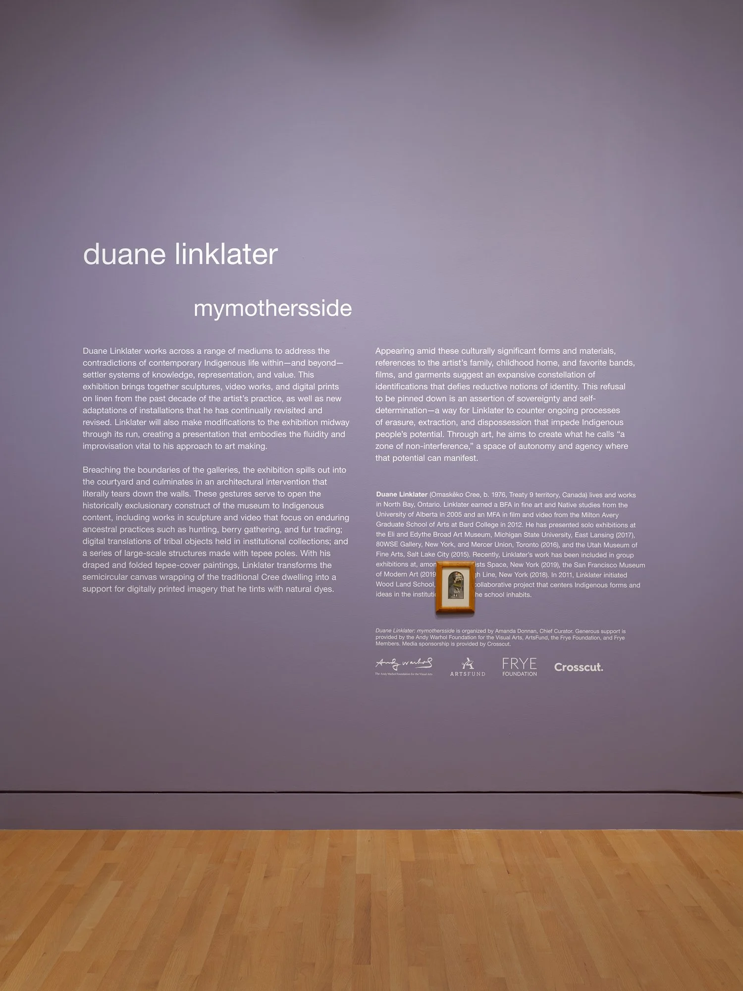 a purple wall with vinyl text and a framed image